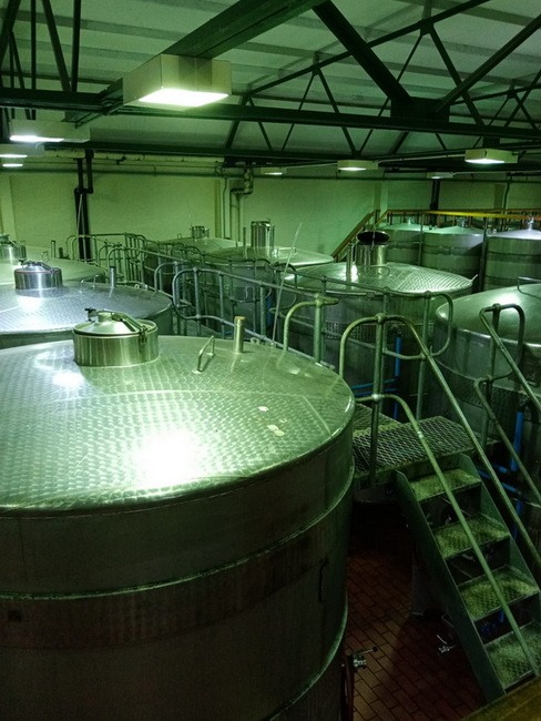 A picture of looking down on wine making tanks in a cellar
